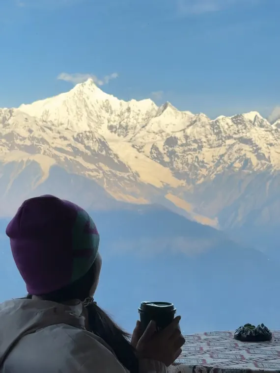 A person looking across a snowy mountain landscape in the original photograph
